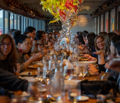group of people sitting at a table eating dinner together